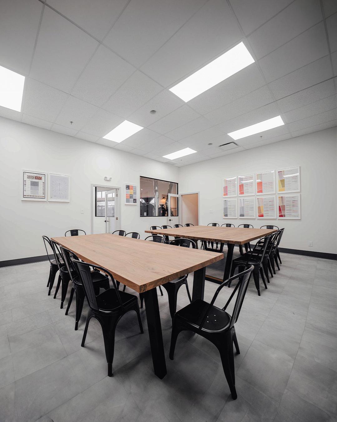 Spacious meeting room with desks, chairs, and an 85” Smart TV setup for presentations.